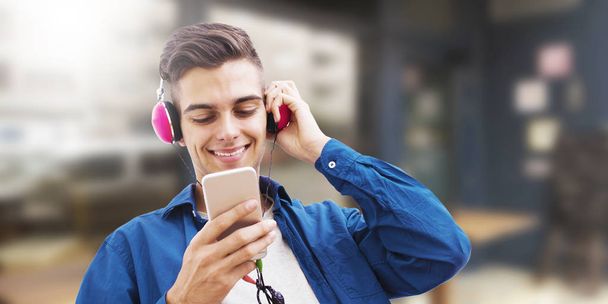 молодой человек с телефоном и наушниками, слушающий музыку
 - Фото, изображение