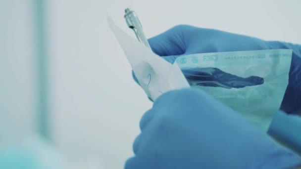 The dentist takes out a syringe and inserts an ampoule into it. - Imágenes, Vídeo