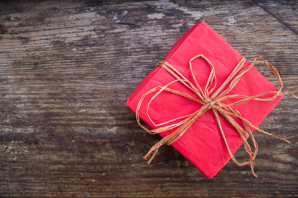 Ajándék karácsonyra, vagy születésnap. Piros doboz ajándék. Ünnepi mezőbe. Stílusos kivitelben. Romantikus ajándék. Újévi ajándéka. Csomagolt ajándék. Piros betakar. Ünnepi kép. Valentin-nap. - Fotó, kép