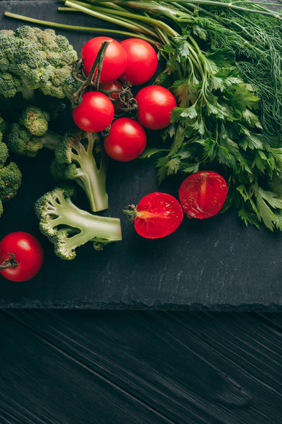 Koyu ahşap bir masa, taze yeşil brokoli, maydanoz, dereotu ve kiraz domates sağlığınız için üzerinde. Tarifi. Malzemeler. Diyet yiyecek. Metnin altında yerleştirin. Üstten görünüm - Fotoğraf, Görsel