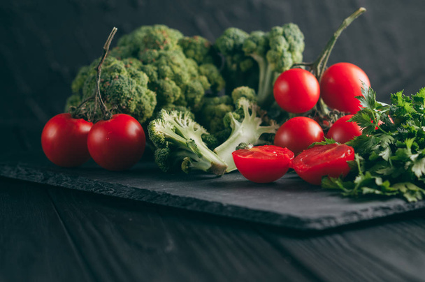 Na tmavý dřevěný stůl, čerstvý zelený brokolice, petržel, kopr a cherry rajčaty pro vaše zdraví. Recept. Ingredience. Dietní jídlo. Umístěte pod textem. Pohled shora - Fotografie, Obrázek