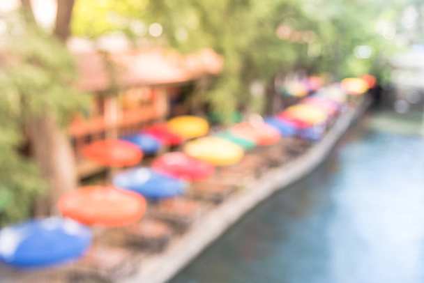 Blur colorful River Walk in downtown San Antonio, multicolor umbrella from outdoor cafe, restaurant along network of walkways along river bank, one story beneath the street of San Antonio, Texas, USA. - Photo, Image