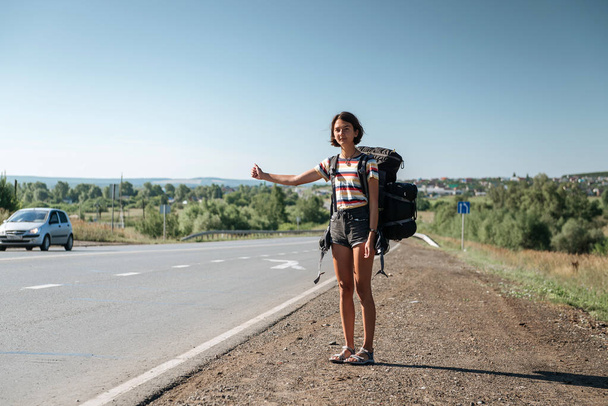 Girl hitchhiking. Backpacker on road - Photo, Image