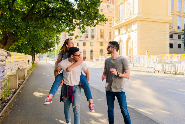 Jovem está abraçando seu amigo enquanto passeia na cidade
 - Foto, Imagem