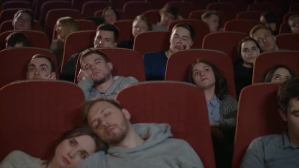 Znudzony widowni oglądania filmu w kinie. Widzów zasnąć od nudny film - Materiał filmowy, wideo