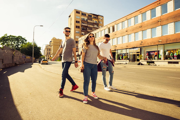 Grupo feliz de jovens caminhando juntos no dia ensolarado
 - Foto, Imagem