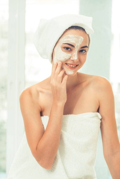 Beautiful woman having a facial cosmetic scrub treatment from professional dermatologist at wellness spa. Anti-aging, facial skin care and luxury lifestyle concept. - Photo, image