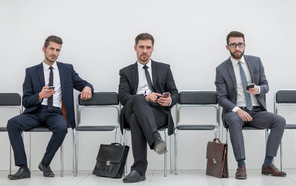 group of business people with smartphones sitting in the office hallway - Zdjęcie, obraz