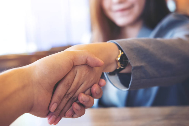 Деловой имидж деловой женщины и бизнесмена, пожимающих друг другу руку в офисе
 - Фото, изображение