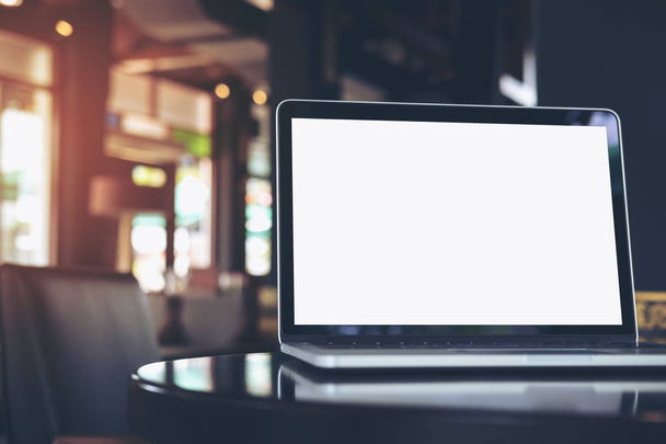 Imagen burlona de portátil con pantalla blanca en blanco en la mesa de madera en la cafetería
 - Foto, Imagen