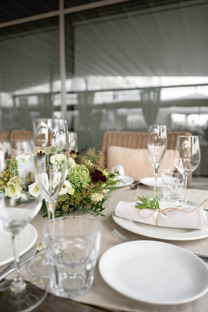 Hochzeitsbankett oder Galadinner. die Stühle und Tische für die Gäste, serviert mit Besteck und Geschirr. bedeckt mit einem Leinentischtuch Läufer. Party auf der Terrasse - Foto, Bild