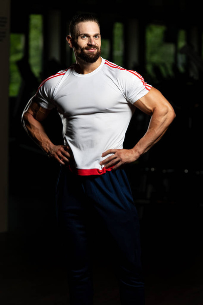 Portrait Of Personal Trainer In Sports Outfit In Fitness Center Gym Standing Strong - 写真・画像