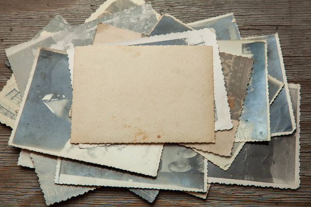Empilhe fotos antigas na mesa. Papel em branco falso. Cartão postal enrugado e sujo vintage
 - Foto, Imagem
