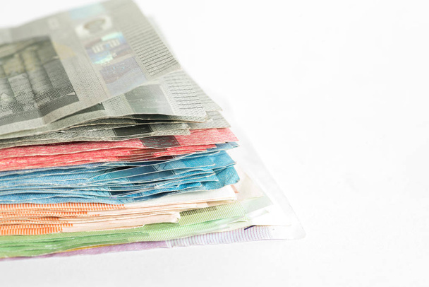 Muchos billetes en euros sobre fondo blanco
 - Foto, imagen