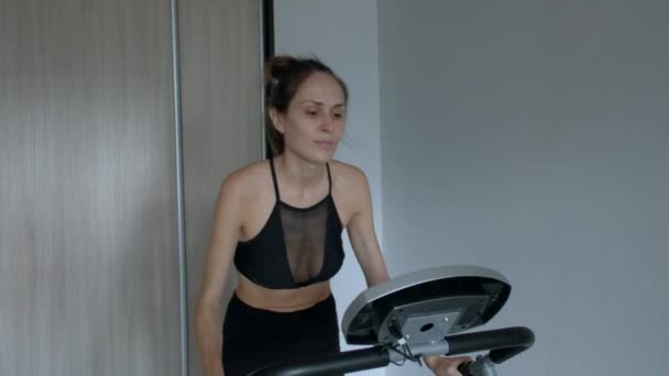 Atraktivní žena doma běží na běžeckém pásu - Záběry, video