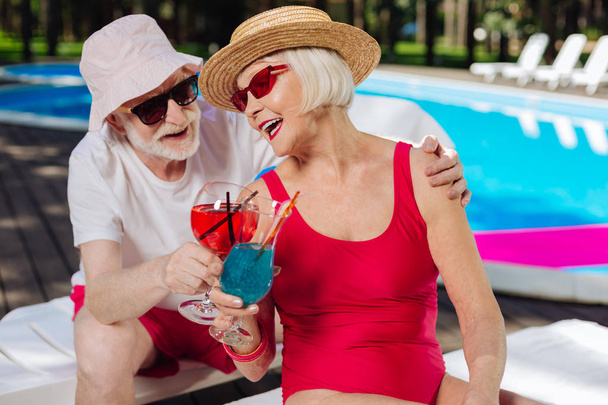 Blonde-haired retired woman listening to jokes of her husband - Valokuva, kuva