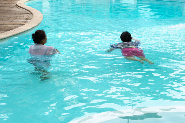 Duas mulheres idosas fazendo exercício de aqua gym na piscina ao ar livre
. - Foto, Imagem