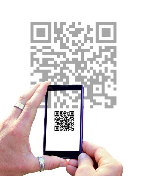 Blick über den Bildschirm des Mobiltelefons beim Scannen des QR-Codes isoliert auf weißem Hintergrund. Hände, die Handy halten und QR-Code scannen. - Foto, Bild