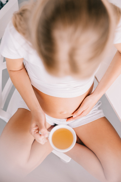 csésze tea otthon a terhes nő felülnézete - Fotó, kép