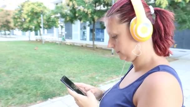     smiling woman walking listen music with headphone  - Πλάνα, βίντεο