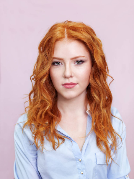 Portrait of beautiful red-haired girl on pink background. - Фото, зображення