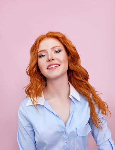 Portrait of beautiful red-haired girl on pink background. - Foto, imagen