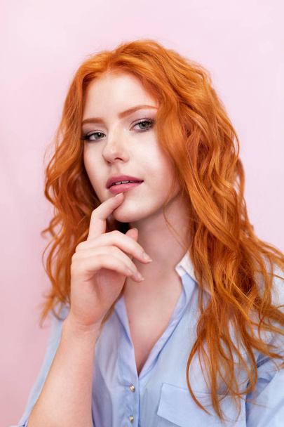 Portrait of beautiful red-haired girl on pink background. - Valokuva, kuva