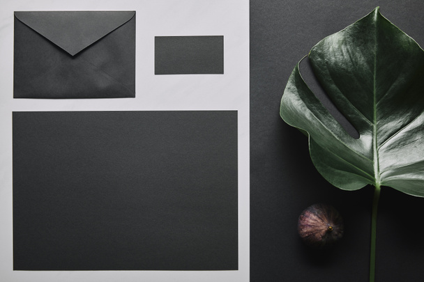 Бизнес-макет с черным конвертом и карточкой на белом мраморном фоне
 - Фото, изображение