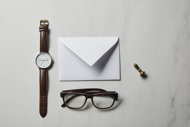 Briefsjabloon met bril en horloge op witte marmeren achtergrond - Foto, afbeelding