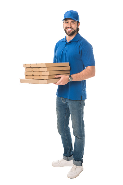 volle lengte weergave van gelukkig levering man houden van vakken met pizza en lachend op camera geïsoleerd op wit - Foto, afbeelding