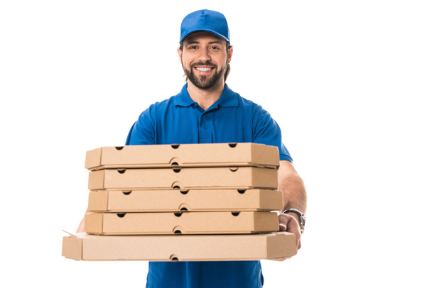 handsome happy delivery man holding boxes with pizza and smiling at camera isolated on white - 写真・画像