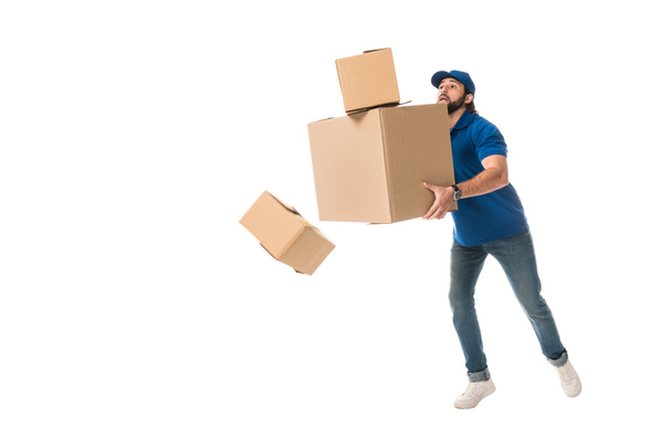 full length view of delivery man holding stacked cardboard boxes falling isolated on white - Foto, Imagem