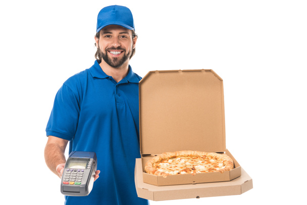 glücklicher Lieferant mit Pizza in Schachteln und Zahlungsterminal, lächelnd in die Kamera, isoliert auf weiß    - Foto, Bild