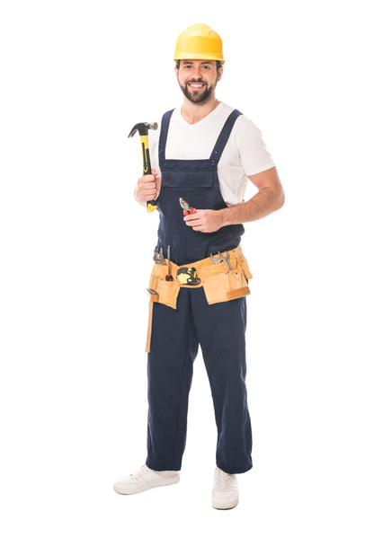 full length view of handsome repairman holding tools and smiling at camera isolated on white - Photo, Image