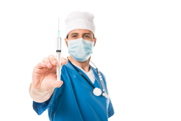 close-up view of doctor in medical mask holding syringe isolated on white - Foto, Imagem