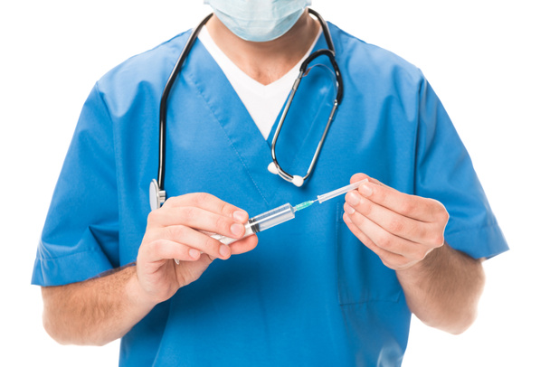 cropped shot of doctor in medical mask holding syringe isolated on white - Фото, изображение