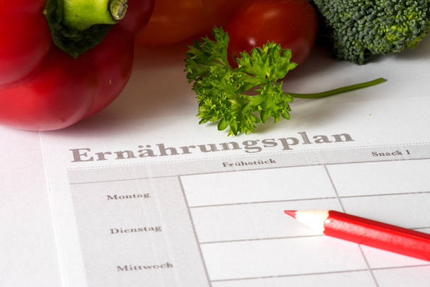 Legumes, um plano nutricional e um Stif vermelho
 - Foto, Imagem