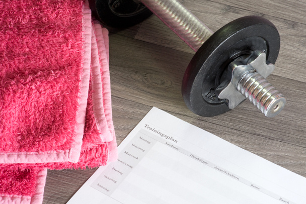 A dumbbell, towel and a workout plan for strength training - Photo, Image