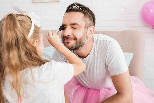 blonde fille faire maquillage avec brosse pour père
 - Photo, image