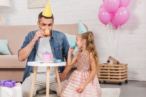 father and daughter playing tea party at home with pink balloons - Φωτογραφία, εικόνα