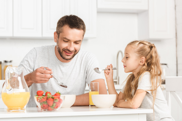 father and daughter having breakfast at kitchen - Фото, изображение
