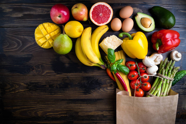 Здоровое питание. Здоровое питание в бумажных мешках овощи, фрукты, макароны, яйца, сыр и грибы на темной. Концепция супермаркета. Вегетарианская еда. Вид сверху. Копирование пространства
 - Фото, изображение