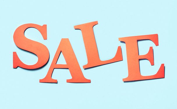 Sale banner. Colourful craft banner for marketing special discount prices or campaign offer. Letters cut from cardboard paper on a light blue background. Hand made red orange text for advertising. - Фото, зображення