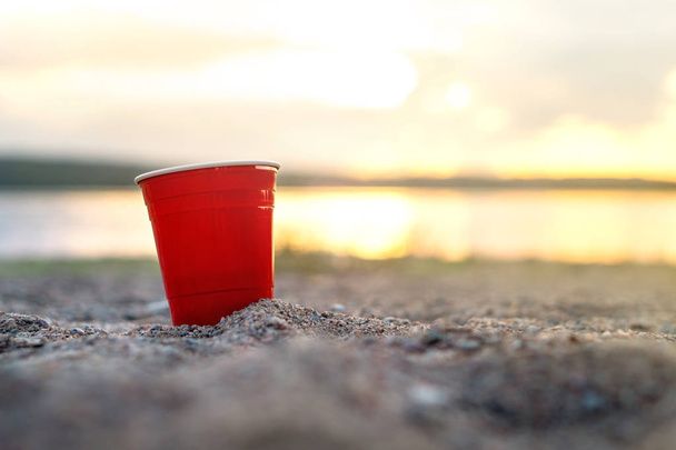 Coppa festa rossa in sabbia al tramonto. Concetto di festa sulla spiaggia estiva con spazio copia
. - Foto, immagini
