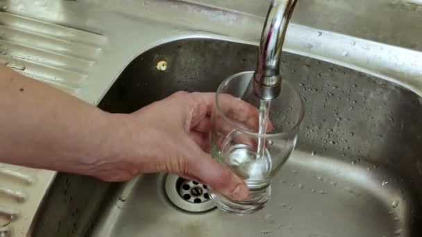 Glas voll Schmutzwasser / Glas voll Schmutzwasser, das aus dem Wasserhahn fließt - Filmmaterial, Video
