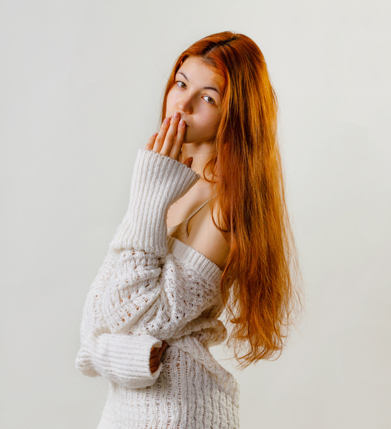 Oops or air kiss. Fashion portrait of cute redhead woman face expression, girl covers her mouth in shock hand, dressed in knitted sweater, posing on grey background copy space. - Photo, Image