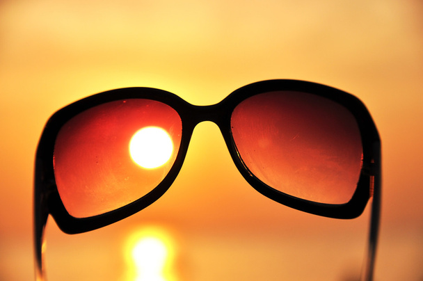 Océano puesta de sol a través de las gafas de sol
 - Foto, imagen