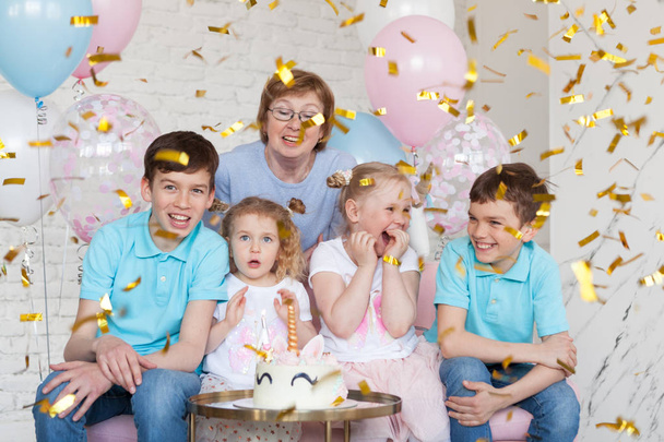 Spaß Geburtstag mit hübschen kleinen Mädchen. Fest mit Einhorn, drinnen, Porträt der Großmutter mit Enkeln - Foto, Bild