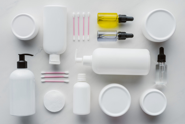 flat lay with bottles of cream, natural oils and cotton swabs on white surface, beauty concept - Photo, Image