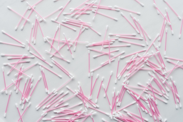 top view of scattered pink cotton swabs isolated on white, beauty concept - Fotó, kép